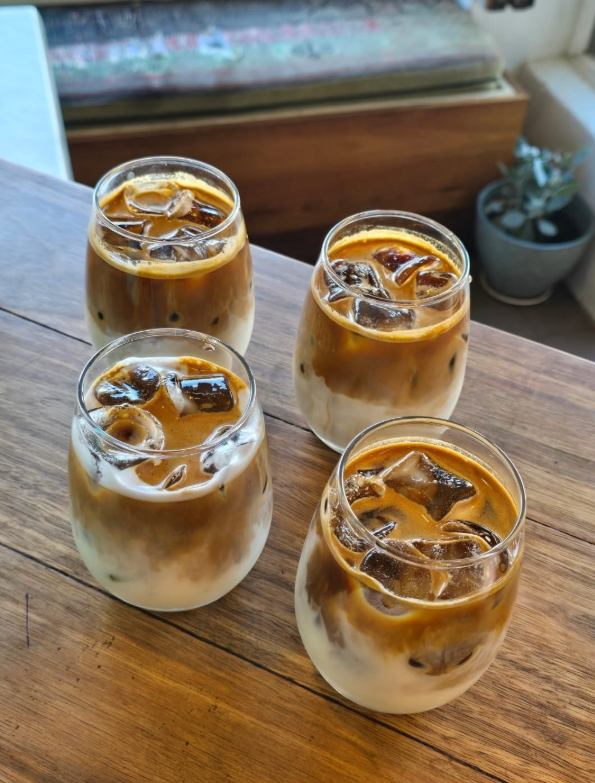 Four iced coffees on a wooden table