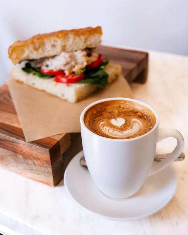 A sandwich served with a latte